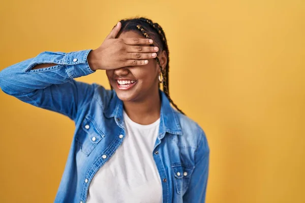 Африканская Американка Косичками Стоящая Жёлтом Фоне Улыбаясь Смеясь Закрывая Глаза — стоковое фото