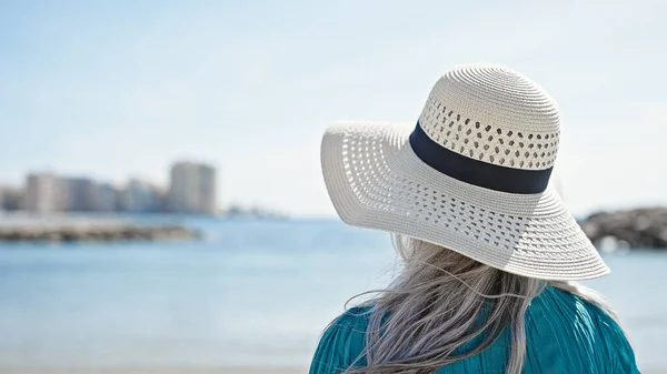 中世の白髪の女性観光客がビーチで後方に立っている — ストック写真