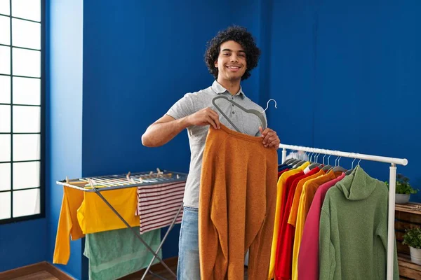 Young Hispanic Man Smiling Confident Hanging Clothes Rack Laundry Room — стоковое фото