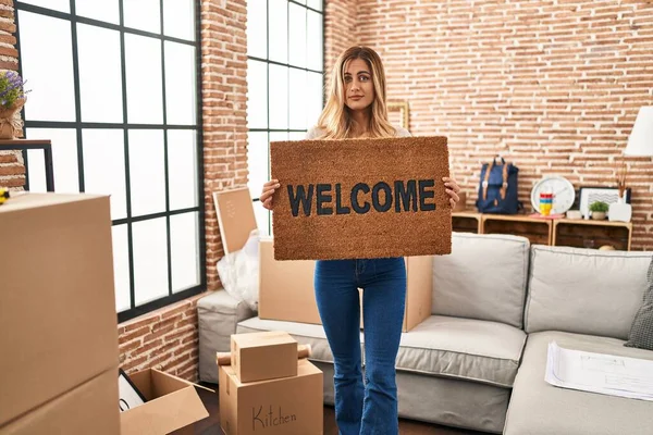Young Blonde Woman Holding Welcome Doormat New Home Clueless Confused — Stock Photo, Image