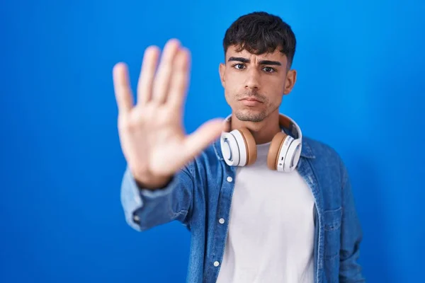 Mavi Arka Planda Dikilen Spanyol Genç Adam Avucunun Içinde Şarkı — Stok fotoğraf