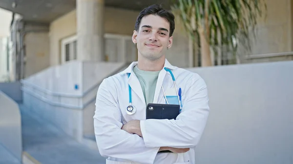 Młody Latynoski Lekarz Stojący Rękoma Skrzyżowanymi Gestem Trzymający Touchpad Szpitalu — Zdjęcie stockowe