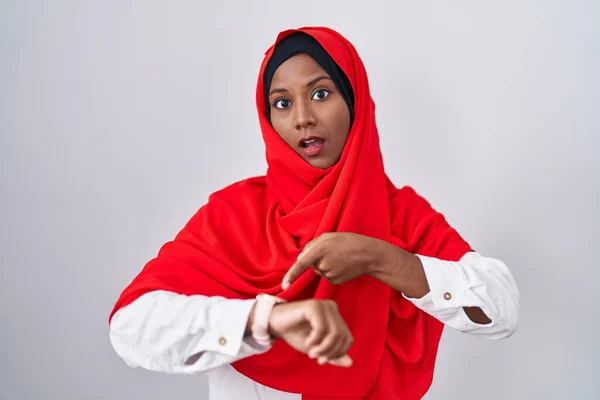 若いですアラブ女性身に着けています伝統的なイスラムヒジャーブスカーフで急いで時間を見ます 動揺し 締め切り遅延のために怒っています — ストック写真