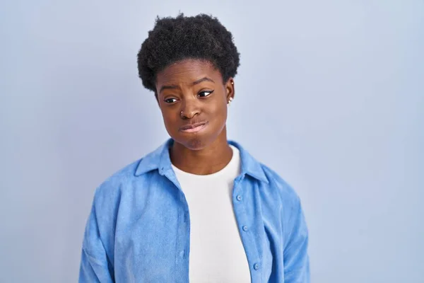 非洲裔美国妇女站在蓝色的背景上 脸上带着滑稽的表情 气喘吁吁的嘴 疯狂的表情 — 图库照片