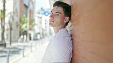 Sokakta kendinden emin gülümseyen İspanyol genç adam.
