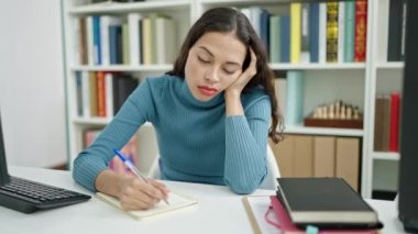 Genç, güzel İspanyol bir öğrenci üniversite sınıfında notlar yazıyor.