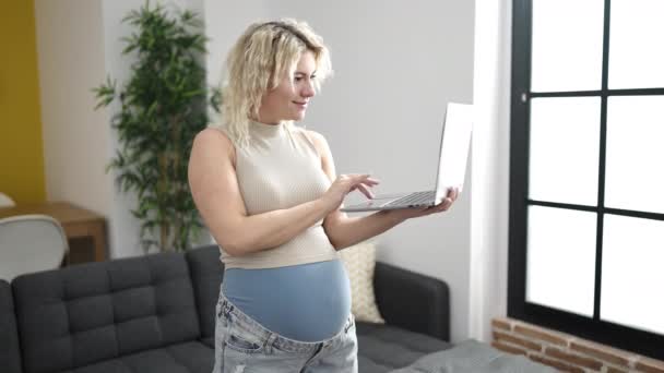 Молодая Беременная Женщина Ноутбука Улыбается Дома — стоковое видео