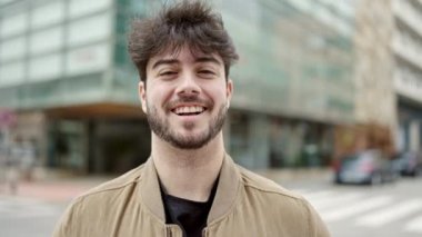 Sokakta kendinden emin gülümseyen İspanyol genç adam.