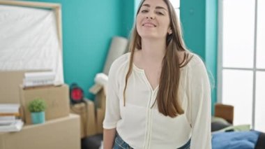 Genç, güzel İspanyol bir kadın yeni evinde kollarını kavuşturup gülümsüyor.
