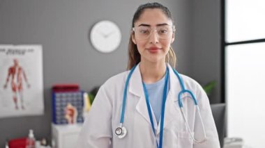 Genç, güzel İspanyol kadın doktor klinikte başparmağını kaldırıyor.