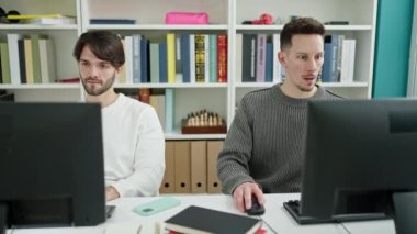 Kütüphane üniversitesinde iki erkek öğrenci beşlik okuyor.