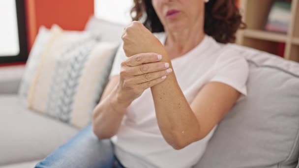 中年惊慌失措的女人坐在沙发上 在家里饱受腕部疼痛之苦 — 图库视频影像