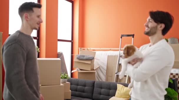 二人の男カップル抱擁お互いに保持犬で新しい家 — ストック動画