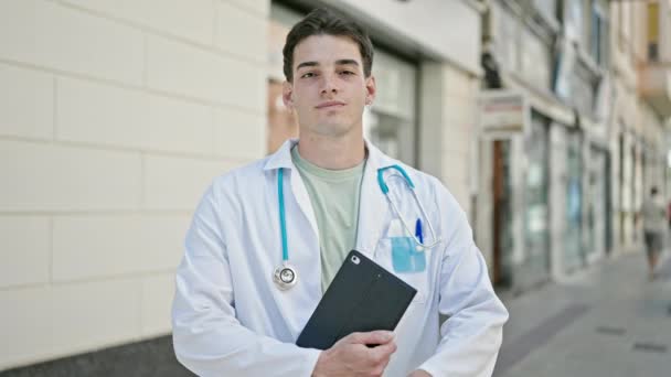 若いですヒスパニック男医師立っていますとともに腕交差ジェスチャー保持タッチパッドで病院 — ストック動画