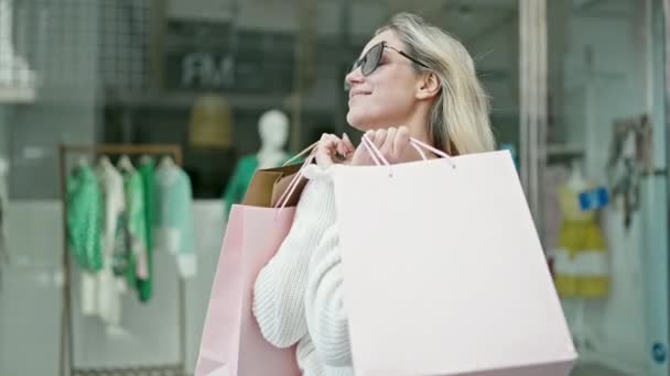 Junge Blonde Frau Lächelt Beim Einkaufen Und Hält Taschen Auf — Stockvideo