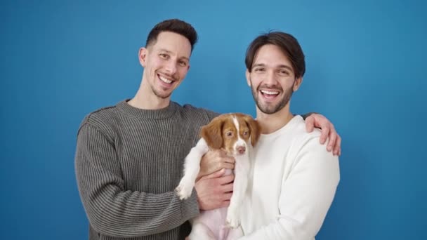 Zwei Männer Paar Lächelt Selbstbewusst Stehend Küssenden Hund Vor Isoliertem — Stockvideo