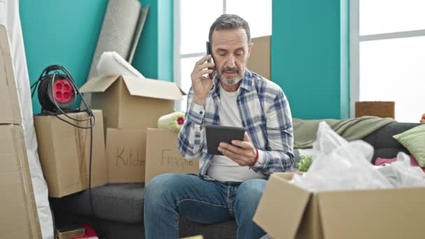 Homem Meia Idade Falando Smartphone Usando Touchpad Nova Casa — Vídeo de Stock