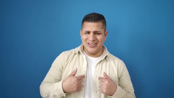Tânăr Hispanic Îndreptându Spunând Degetul Peste Fundal Albastru Izolat — Videoclip de stoc