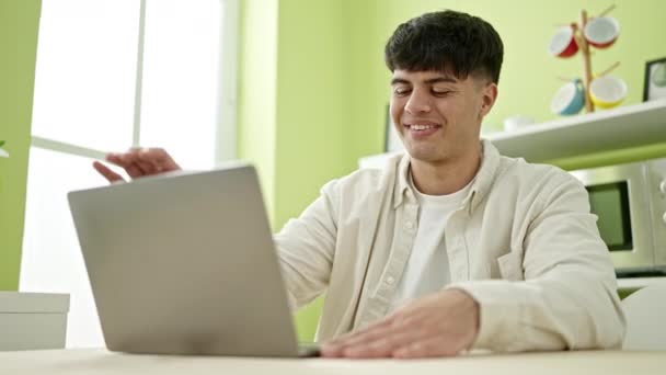 Junger Hispanischer Mann Sitzt Mit Laptop Auf Tisch Esszimmer — Stockvideo