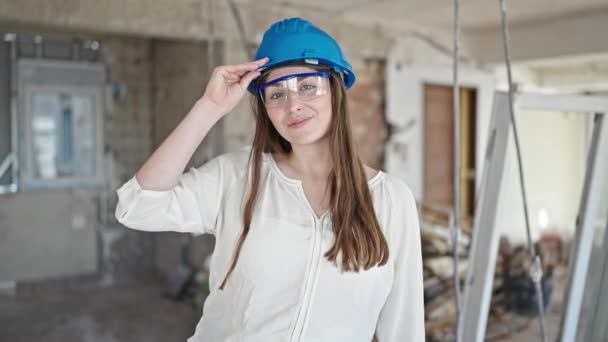 Young Beautiful Hispanic Woman Builder Smiling Confident Taking Out Hardhat — Stock Video