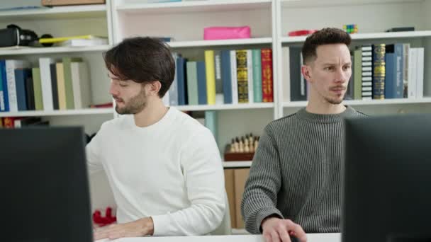 Dos Hombres Estudiantes Usando Computadora Comiendo Masa Universidad Biblioteca — Vídeo de stock