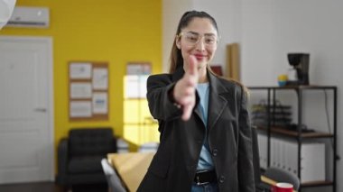 Genç, güzel İspanyol iş kadını gülümseyen, kendine güvenen, ofiste tokalaşan.