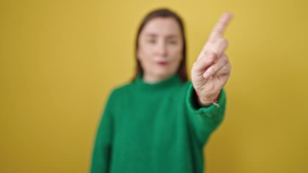 Зріла Іспаномовна Жінка Сірим Волоссям Каже Пальцем Над Ізольованим Жовтим — стокове відео