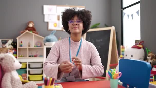 Młoda Afrykańska Amerykanka Przedszkolanka Uśmiechnięta Pewna Siebie Siedząca Stole Rękoma — Wideo stockowe