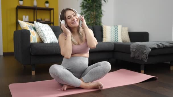 Mujer Embarazada Joven Escuchando Música Sentada Esterilla Yoga Casa — Vídeo de stock