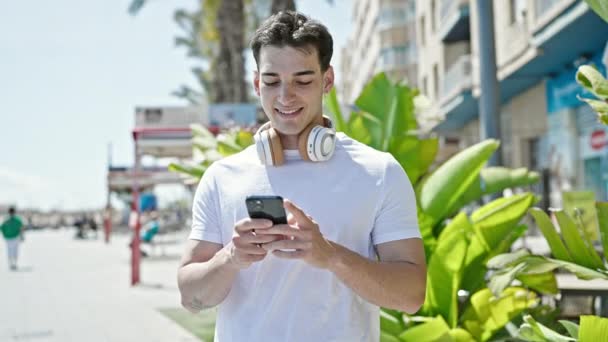 Jeune Homme Hispanique Souriant Confiant Utilisant Smartphone Dans Rue — Video
