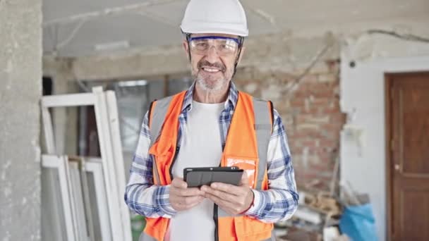 中年男子建筑工人微笑自信地使用触摸板在建筑工地 — 图库视频影像