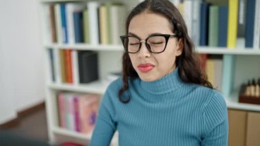 Üniversite sınıfında yorgun ve stresli gözlük takan genç ve güzel İspanyol bir kız öğrenci.