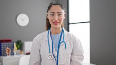 Genç ve güzel İspanyol kadın doktor klinikte parmaklarıyla hayır diyerek gülümsüyor.