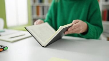 Kütüphanede gri saçlı, kitap okuyan olgun İspanyol kadın.