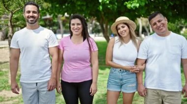 Parkta birbirlerine gülümseyen bir grup insan.