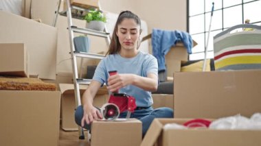 Genç, güzel İspanyol kadın yeni evinde karton kutu paketliyor.
