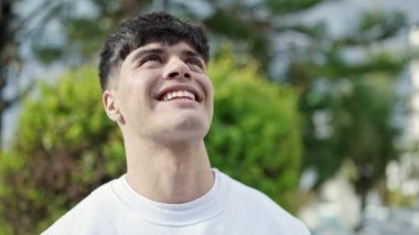 Parkta gökyüzüne bakan İspanyol asıllı genç adam.