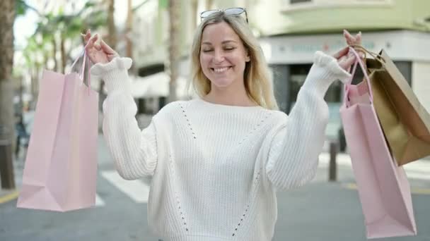 Junge Blonde Frau Geht Einkaufen Und Hält Tüten Der Hand — Stockvideo