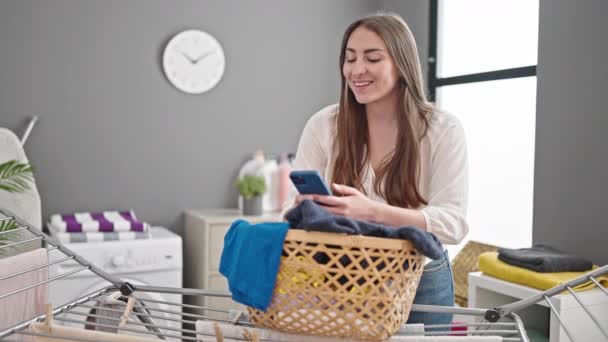 아름다운 스페인 여자가 세탁실의 빨랫줄에 스마트폰걸어 사용하는 — 비디오