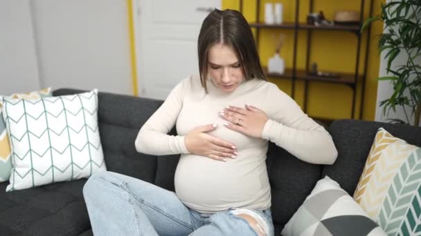 Jonge Zwangere Vrouw Onderzoekt Borst Zitten Bank Thuis — Stockvideo