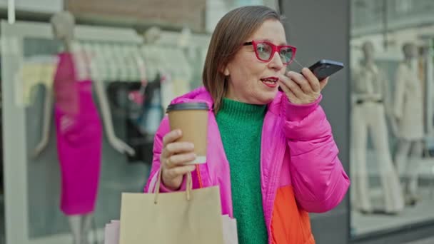 他的惊慌失措的女人面带微笑地购物 在服装店用智能手机发送语音讯息 — 图库视频影像