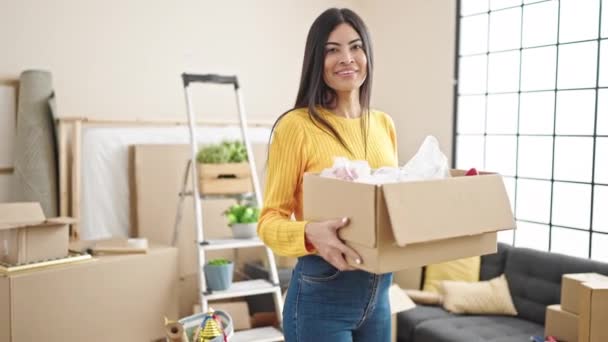 Young Beautiful Hispanic Woman Smiling Confident Holding Package New Home — Stockvideo