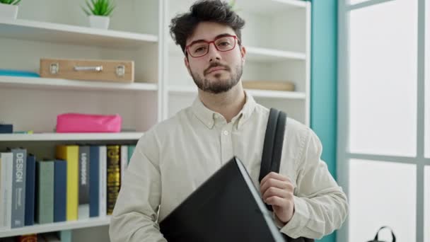 Jonge Spaanse Man Student Glimlachend Zelfverzekerd Holding Binder Bij Bibliotheek — Stockvideo