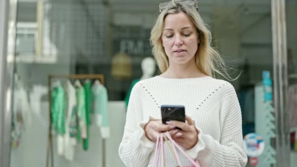 Mujer Rubia Joven Compras Sosteniendo Bolsas Usando Smartphone Calle — Vídeos de Stock