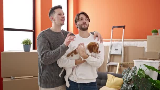 Двое Мужчин Обнимают Друг Друга Держат Собаку Новом Доме — стоковое видео