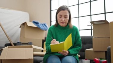 Not defterine gri saçlı, olgun İspanyol bir kadın. Yeni evindeki koltukta oturuyor.