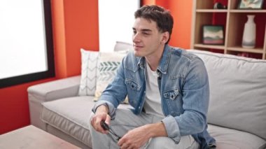 Evdeki kanepede oturan İspanyol asıllı genç adam.