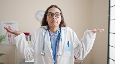Genç, güzel İspanyol kadın doktor klinikte bilgisiz duruyor.