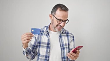 Akıllı telefon ve kredi kartı kullanan orta yaşlı bir adam izole edilmiş beyaz arka plan üzerinde
