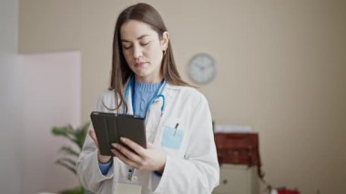 Genç beyaz kadın doktor klinikte dokunmatik ped kullanıyor.